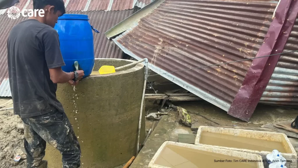 A survivor in Teluang Hemlet washed his hands using makeshift stored water collected from the nearby river